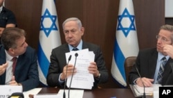 2023年7月17日,以色列总理本杰明·内塔尼亚胡(中)、外交部长伊莱·科恩(左)和内阁秘书约西·福克斯(右)在耶路撒冷总理办公室出席内阁会议。(美联社照片)