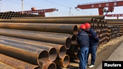 河北沧州华洋钢管有限公司的工人在检查钢管质量(资料照片)