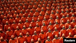 2021 年 9 月 9 日在平壤金日成广场举行的朝鲜国庆73周年的检阅仪式上穿着橙色防护服的人员在行进。(路透社)