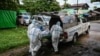 Volunteers wearing personal protective equipment (PPE) prepare to transport the body of a victim of the Covid-19 coronavirus to a cemetery in Hlegu Township in Yangon on July 10, 2021. (Photo by Ye Aung THU / AFP)