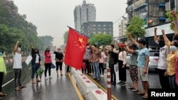 资料照片:在缅甸仰光举行的反对中国的示威活动中,反政变抗议者举着一面中国国旗,准备将其焚烧。(2021年4月5日)