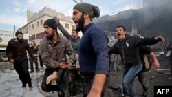 在叙利亚政府军的空袭之后,人们从瓦砾中寻找出死难者的尸体。