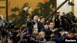 各国记者在等待中国国家主席习近平和其他中共中央政治局常委到达北京人大会堂。(2017年10月25日)