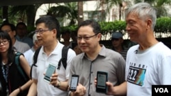 占中三位发起人展示手机电子投票应用程序(美国之音海彦拍摄)