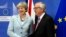英国首相特蕾莎.梅（左）和欧洲委员会主席容克在布鲁塞尔谈判前握手