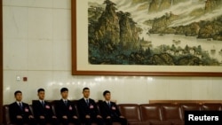 2018年3月18日在北京人民大会堂举行的全国人民代表大会全体会议上,安全人员坐在他们的座位上,姿势整齐划一。