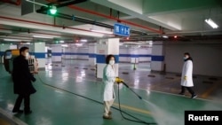 消毒人员在长沙一座地下停车场喷洒消毒药物。(2020年1月30日)