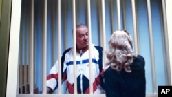 谢尔盖·斯科利帕在铁窗后与律师交谈。(2006年8月9日 :资料照)