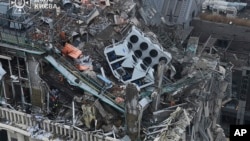 乌克兰国家紧急事务局提供的照片显示,俄罗斯导弹攻击基辅后,消防人员在一座被损坏的大楼现场工作。(2024年12月20日)