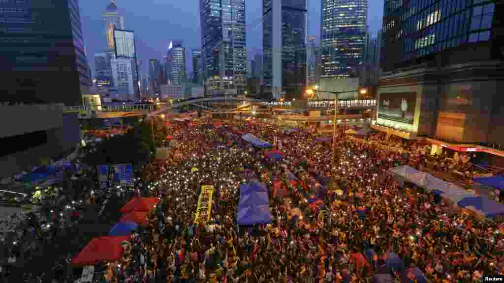 示威者手持横幅,打开手机灯光纪念抗议满月