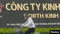 一位男士骑自行车路过河内城外兴安省越南京都集团的一家工厂。(资料照)