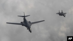 韩国国防部图片显示美国空军B-1B枪骑兵型轰炸机(左)和韩国F-15K战斗机在朝鲜半岛上空飞行(2017年6月30日)