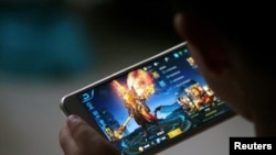 山东德州一孩子在家玩手游“王者荣耀”。这款手游是由腾讯公司提供。(路透社资料照,2017年7月2日)