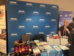 维吾尔人权项目(UHRP)工作人员在2025年国际宗教自由峰会(IRF Summit)上与参会者交谈,讨论中共政权对维吾尔穆斯林实施的种族灭绝罪行。(美国之音薛小山拍摄)