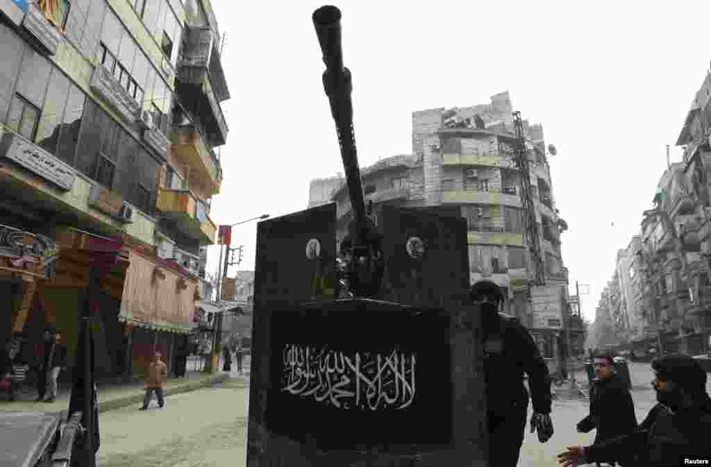 Các thành viên của quân đội Giải phóng Syria đứng sau các ụ súng máy tại thị trấn Al Qaser ở Syria, ngày 2/1/2013.