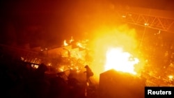 香港理工大学的抗议者站在燃烧的大火旁。(2019年11月18日)