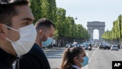 随着法国逐步解除Covid-19封锁,人们戴上口罩以帮助遏制冠状病毒在巴黎香榭丽舍大道上的传播。(2020年5月16日)
