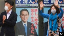 2021年20月27日将举行的一次竞选集会上,日本执政的自民党一个支持者在自民党领袖、首相岸田文雄的竞选广告前挥手。(美联社)