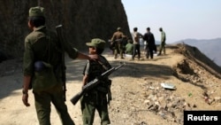 果敢反政府武装“缅甸民族民主同盟”的一名15岁士兵和其他反政府武装士兵一道站岗。(2015年3月12日)