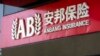 People walk past an entrance to the Anbang Insurance Group's offices in Beijing, June 14, 2017. 