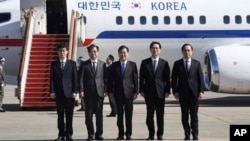 韩国高级国家安全顾问郑义荣(中)、韩国国家情报院院长徐薰(左二)与韩国代表团其他成员在首尔的一个军事基地登机前合影。(2018年3月5日)