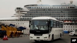 "钻石公主“号邮轮停靠在日本横滨港进行隔离。一辆巴士驶离港口。2020年2月15日照片。