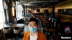 上海市中心seul&SEUL饭店的老板Bill Hu戴着口罩站在空无一人的店堂里。(2020年2月12日)