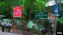 缅甸街头各政党的竞选海报,左侧红色的为该地区民盟候选人,右侧绿色的是该地区巩发党候选人。(图片摄影:朱诺)