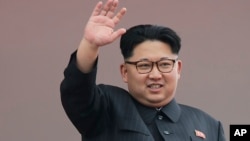 朝鲜领导人金正恩在平壤向在金日成广场上的庆祝游行队伍挥手致意。(2016年5月10日)