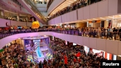 香港人在东京奥运举行期间在商场内观看香港游泳选手何诗蓓参加女子100米自由泳决赛并为她呐喊打气 (路透社照片)