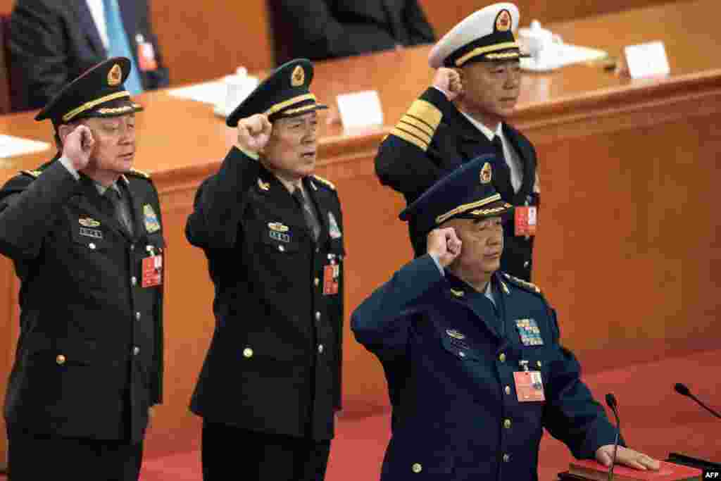 在中国人大全会上当选的中华人民共和国中央军委成员在北京人民大会堂宣誓就职。照片上有副主席许其亮(前)和副主席张又侠(左),委员、似将担任国防部长的魏凤和(左二),委员、中央军委政治工作部主任苗华(右,2018年3月18日) 。