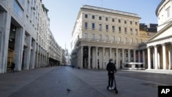 在意大利米兰,一名戴着口罩的男子正在骑着滑板车。(2020年3月11日)