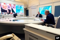 俄罗斯总统普京在莫斯科通过视频出席G20峰会,屏幕上是峰会主持人,印度总理莫迪。(2023年11月22日)