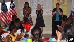 Đệ nhất phu nhân Hoa Kỳ Michelle Obama (trái) được các giáo viên và học sinh của dự án Peace Corp chào đón tại Monrovia ở Kakata, Liberia, ngày 27 tháng 6 năm 2016.