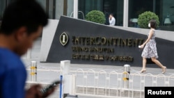 资料照片:一位男士在北京三里屯一家酒店外看手机。国际酒店曾经是中国境内为数不多的可以翻越防火墙的地方,但当局加紧了网络封堵。(2017年8月1日)