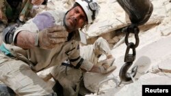 Một nhân viên cứu nạn tại địa điểm bị không kích ở Aleppo, 25/4/14