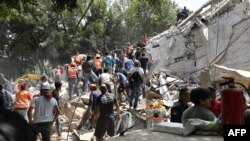 人们在墨西哥城建筑物倒塌造成的瓦砾中搜救(2017年9月19日)