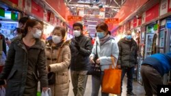 戴口罩的民众在北京一个市场购物。(2020年3月14日)