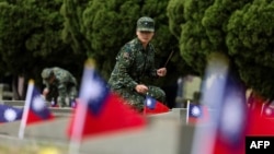 资料照片:一名台湾军人在金门古宁头战役75周年纪念仪式上为公共墓地的一座坟墓上香。(2024年10月25日)