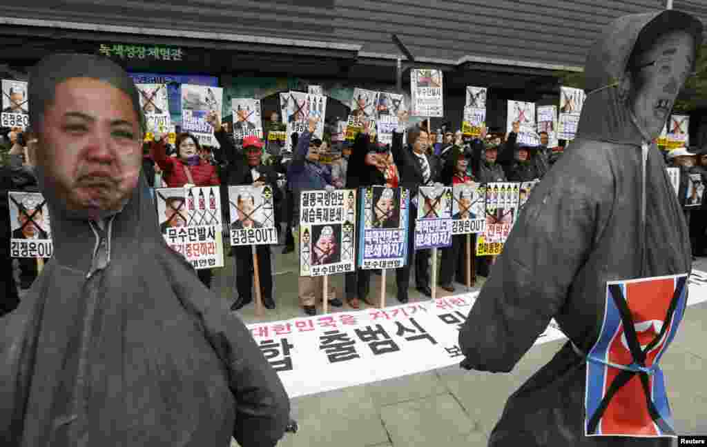 2013年4月15日,反对朝鲜的抗议者在韩国首都首尔市中心举着金正恩和其父金正日的画像呼喊口号。