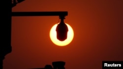 资料照：北京天安门广场上监控摄像镜头后的朝阳（2019年10月1日）