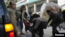 2013年1月10日,一名抗议者在广州《南方周末》总部外被便衣警察带走,塞入一辆吉普车。