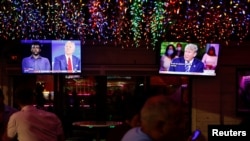 美国佛罗里达州一间餐馆的顾客观看同时进行的两场市民大会式总统大选辩论转播(路透社2020年10月15日)