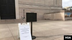 华盛顿史密森尼国家美术馆大门紧闭,门口告示牌向游人解释博物馆因联邦政府关闭而关门。(2019年1月23日)