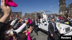 教宗方济各在墨西哥城向欢迎人群招手致意。 (2016年2月13日)