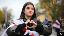 在明斯克星期天的抗议中,一位白俄罗斯妇女比出抗议的手势。