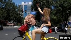 资料照片:一位女士在北京中兴通讯公司大楼附近自拍。(2018年8月29日)