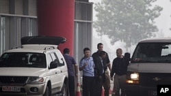 中国过去海外追讨的成果之一,2011年7月23日赖昌星被遣返中国,押送他的加拿大警官(右中)在北京国际机场与中国警官交谈。