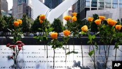 在纽约9/11纪念博物馆,鲜花插在刻在墙上的死难者姓名上。(2020年9月11日)