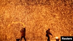 Performers throw molten iron against a wall to create sparks during a traditional performance ahead of the Dragon Boat festival in Zhangjiakou, Hebei province, China May 29, 2017.